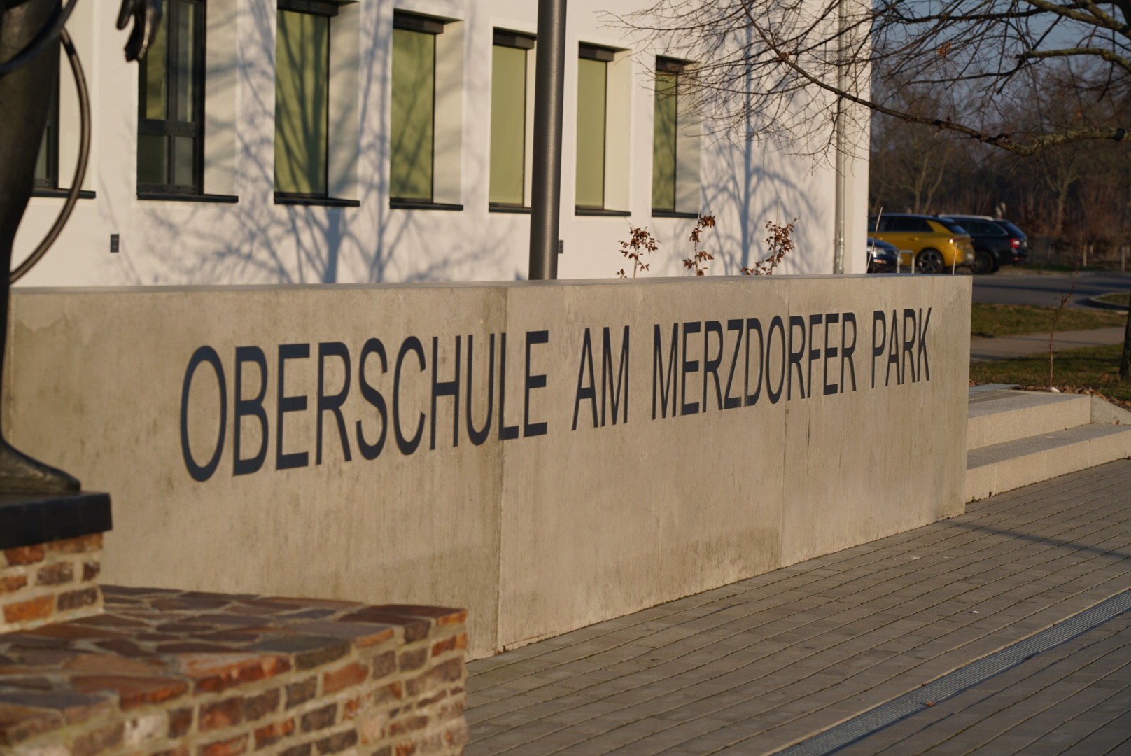 Das Bild zeigt den Eingang der Oberschule. Auf den Steinen steht Oberschule Am Merzdorfer Park.